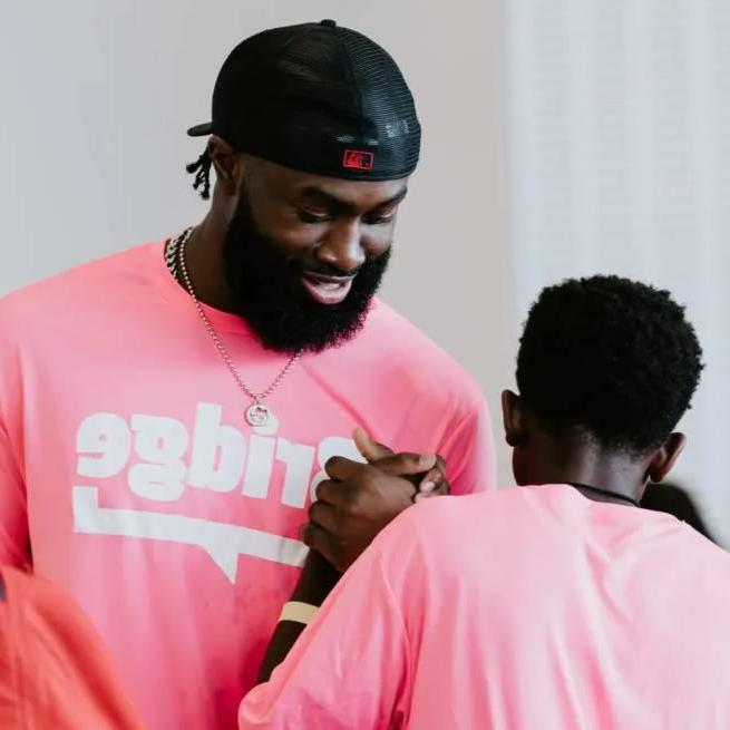 jaylen brown shakes hand with a young student